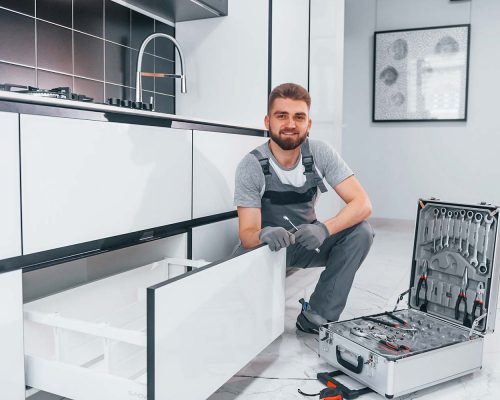 young-professional-plumber-in-grey-uniform-using-e-resize.jpg